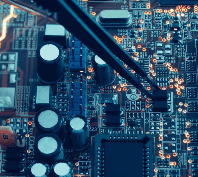 A close up of a circuit board with a pair of tweezers.